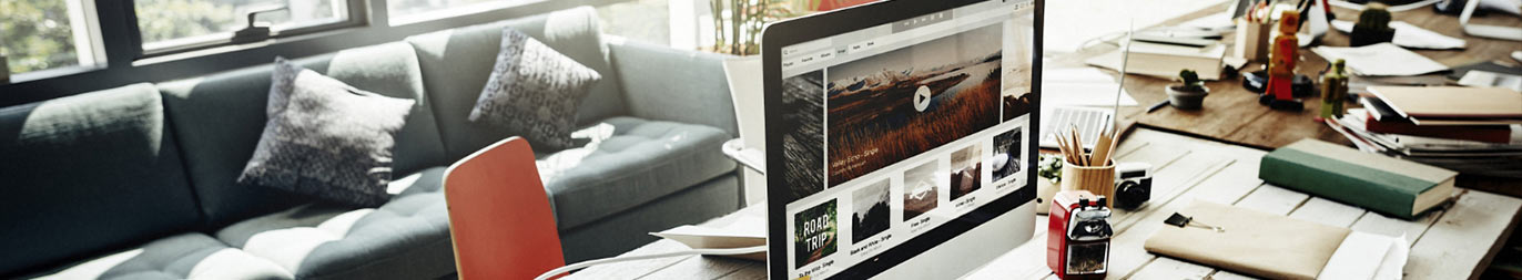 Ein Webdesigner Office mit Desktop und präsentierter Website.